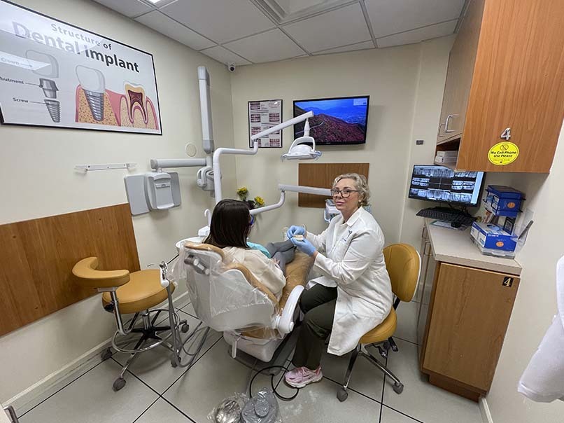 Full mouth dental implant consultation with a dentist discussing treatment options with a patient at Atlas Park Dental in Glendale, NY.