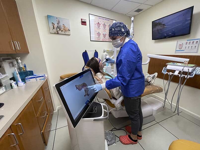 Orthodontist performing digital Invisalign scan during patient appointment at Atlas Park Dental