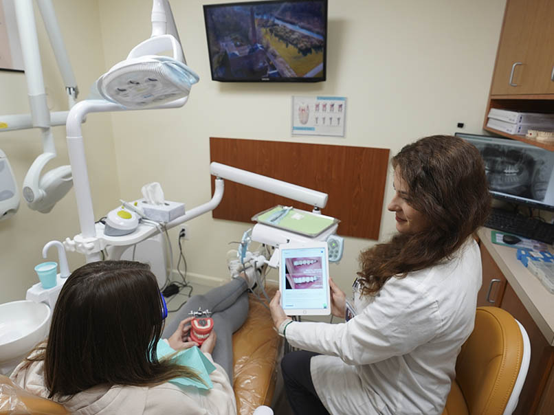 Dentist discussing oral surgery treatment options with a patient at Atlas Park Dental in Glendale, Queens, NY