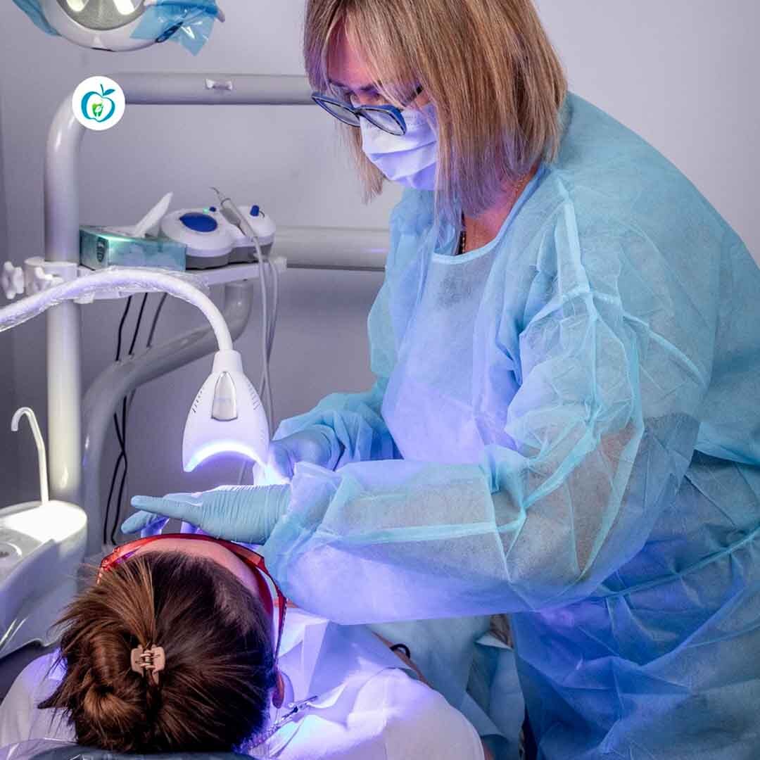 Dental hygienist performing professional teeth cleaning using ultrasonic scaling as part of preventive dental care at Atlas Park Dental in Queens